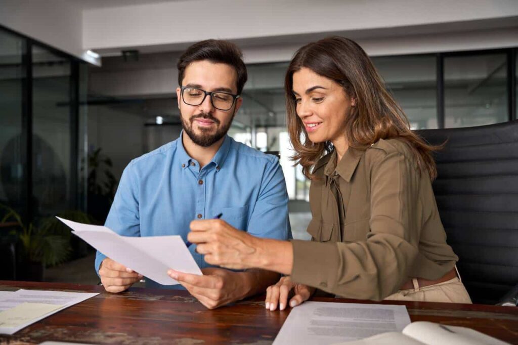 Homem e mulher analisando as finanças de uma empresa e considerando a possibilidade de contratar um bpo financeiro.